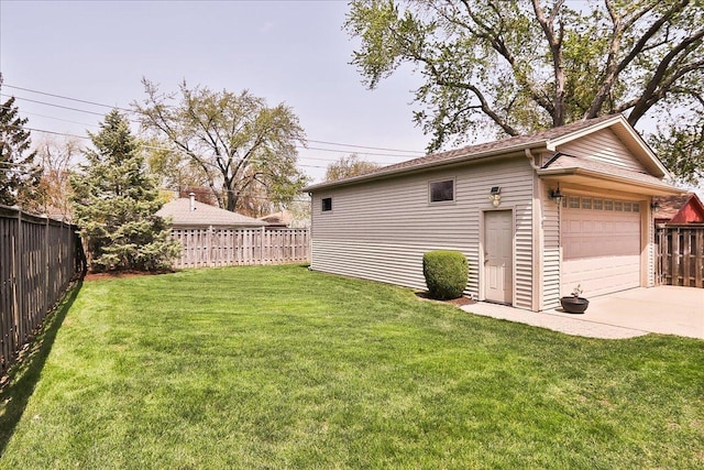view of yard featuring a detached garage, an outdoor structure, and a fenced backyard