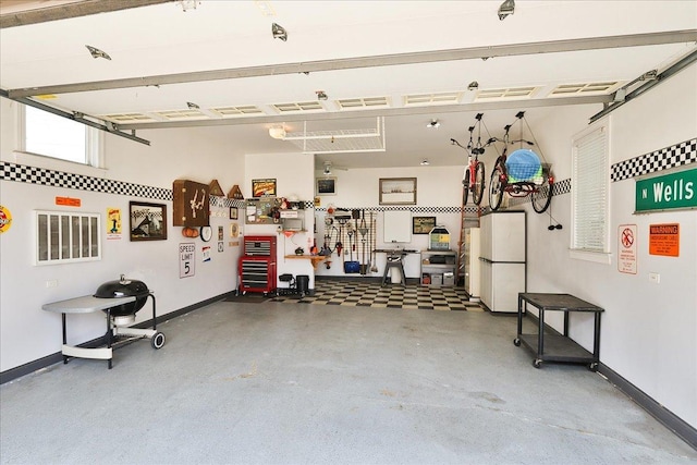 garage featuring freestanding refrigerator and baseboards