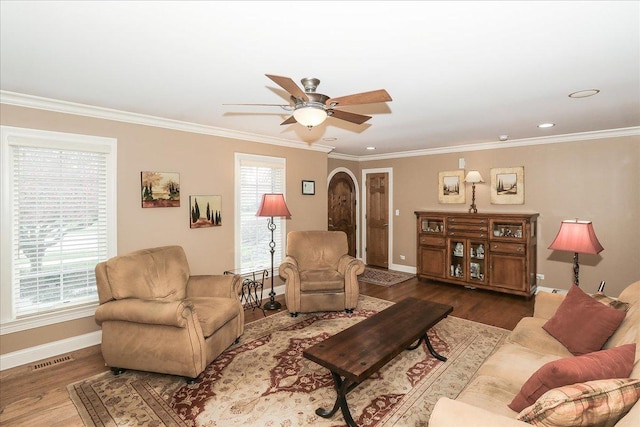 living area featuring crown molding, baseboards, ceiling fan, and wood finished floors