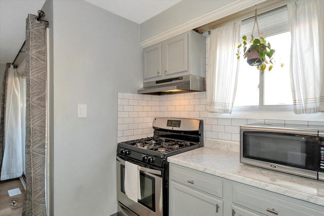 kitchen with stainless steel appliances and backsplash