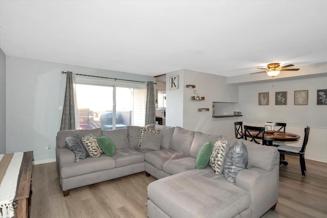 living room with ceiling fan and light wood-type flooring