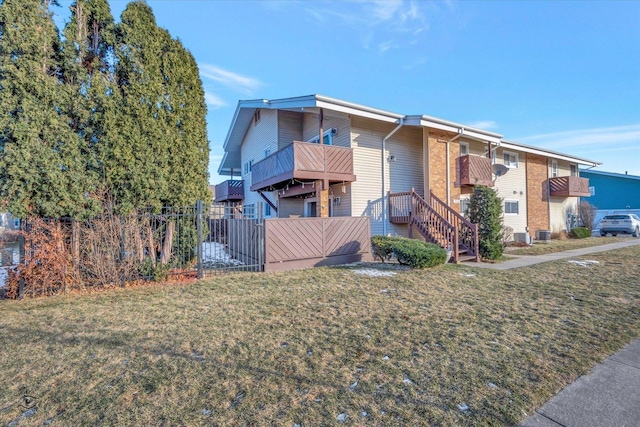 view of front of home featuring a balcony and a front yard