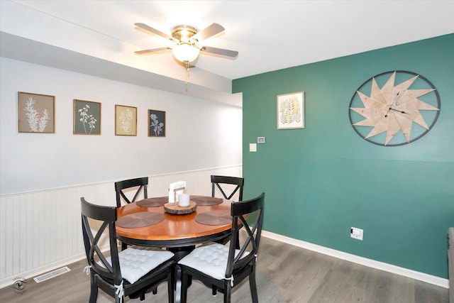 dining space with ceiling fan and dark hardwood / wood-style flooring