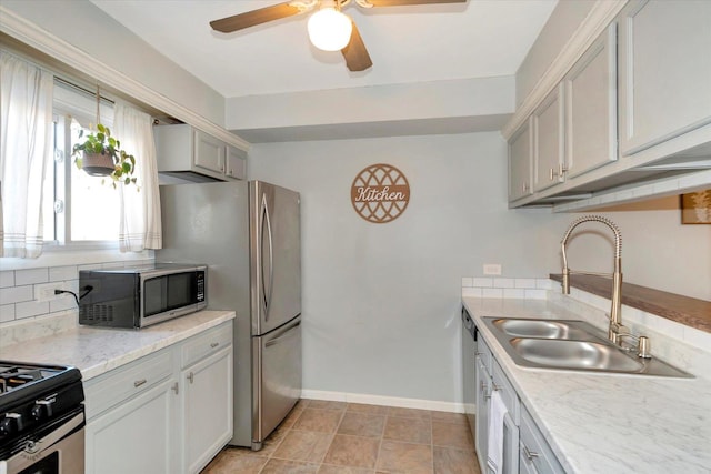 kitchen featuring sink, light tile patterned floors, ceiling fan, and appliances with stainless steel finishes