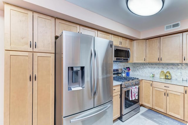 kitchen with decorative backsplash, light brown cabinets, and stainless steel appliances