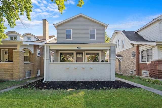 view of front of property with covered porch and a front yard