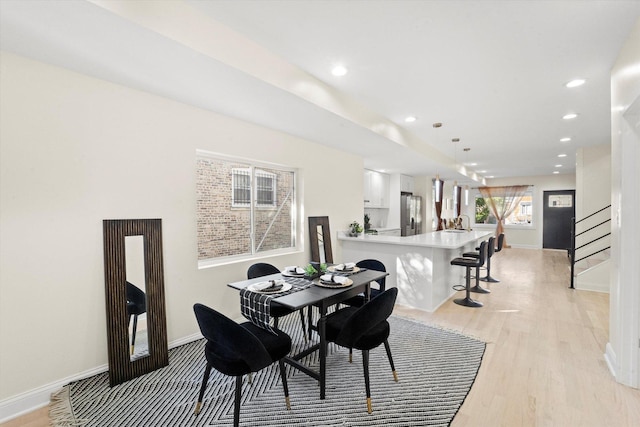 dining area featuring light wood-type flooring and sink