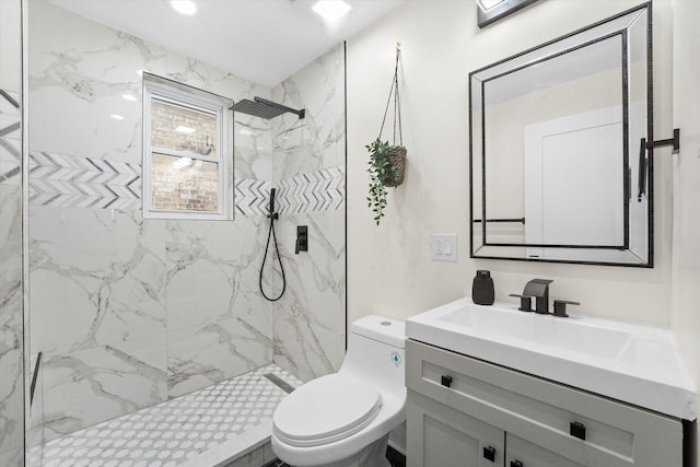 bathroom featuring toilet, vanity, and tiled shower