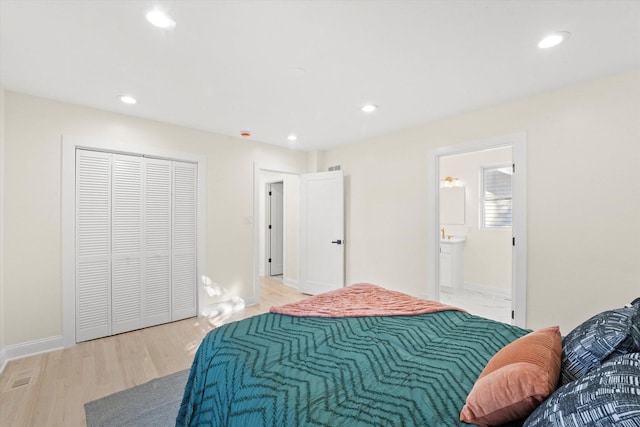 bedroom with a closet, ensuite bathroom, and light hardwood / wood-style flooring