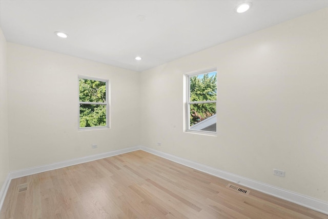 unfurnished room featuring light hardwood / wood-style flooring and a healthy amount of sunlight