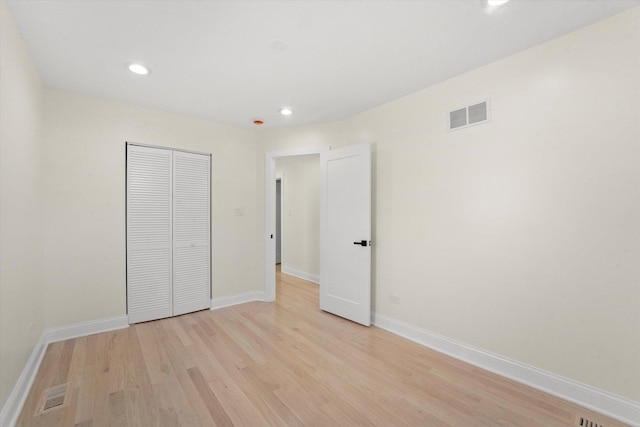 unfurnished bedroom featuring a closet and light wood-type flooring