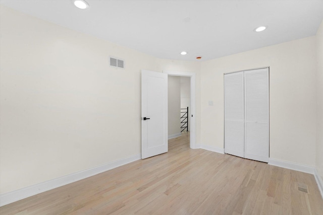 unfurnished bedroom with light hardwood / wood-style floors and a closet