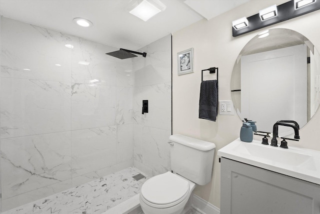 bathroom with toilet, vanity, and a tile shower