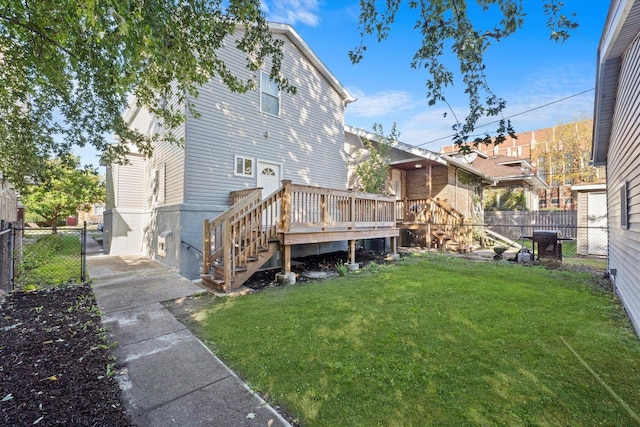 rear view of property featuring a wooden deck and a yard