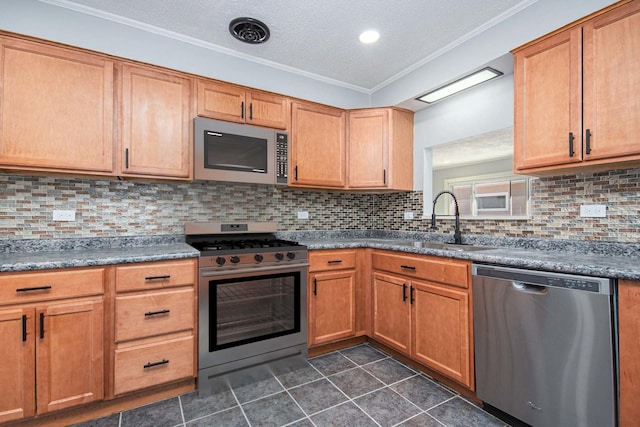 kitchen featuring appliances with stainless steel finishes, backsplash, a textured ceiling, crown molding, and sink