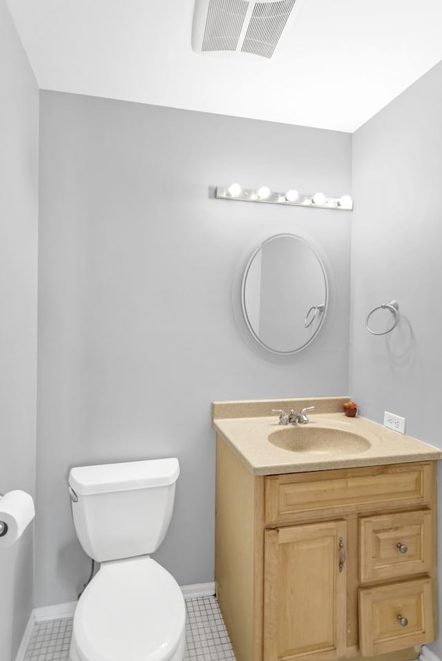 bathroom featuring toilet, vanity, and tile patterned floors