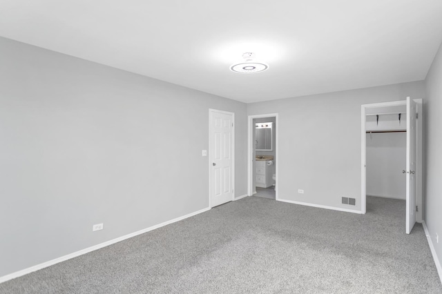 unfurnished bedroom featuring carpet floors and ensuite bathroom