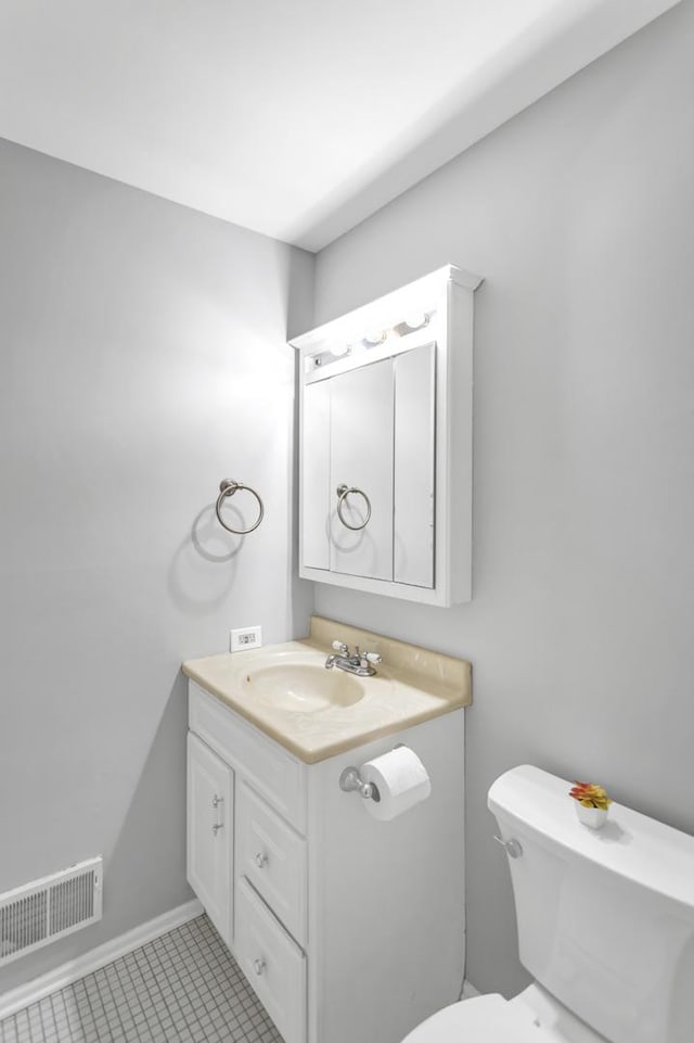 bathroom featuring toilet, tile patterned floors, and vanity