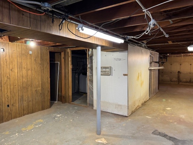 basement with washer / clothes dryer and wood walls