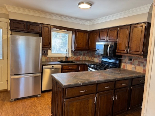 kitchen featuring decorative backsplash, dark brown cabinets, sink, and stainless steel appliances