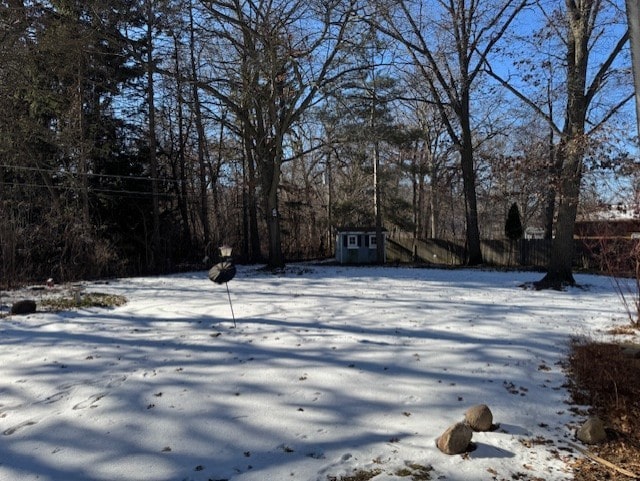 yard layered in snow with a storage unit