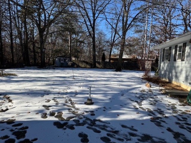 yard covered in snow featuring a storage unit