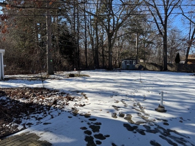 snowy yard with a shed