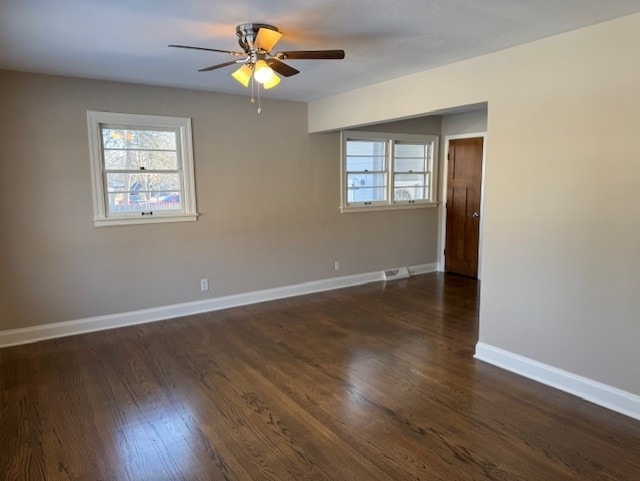 spare room featuring ceiling fan and dark wood-type flooring