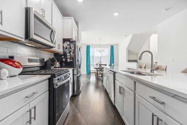 1276 Lakepointe Dr, Schaumburg, IL 60173 - kitchen with stainless steel appliances, a chandelier, dark wood finished floors, decorative backsplash, and white cabinets
