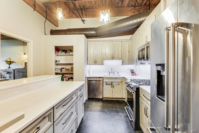 kitchen featuring cream cabinetry, sink, high quality appliances, and pendant lighting