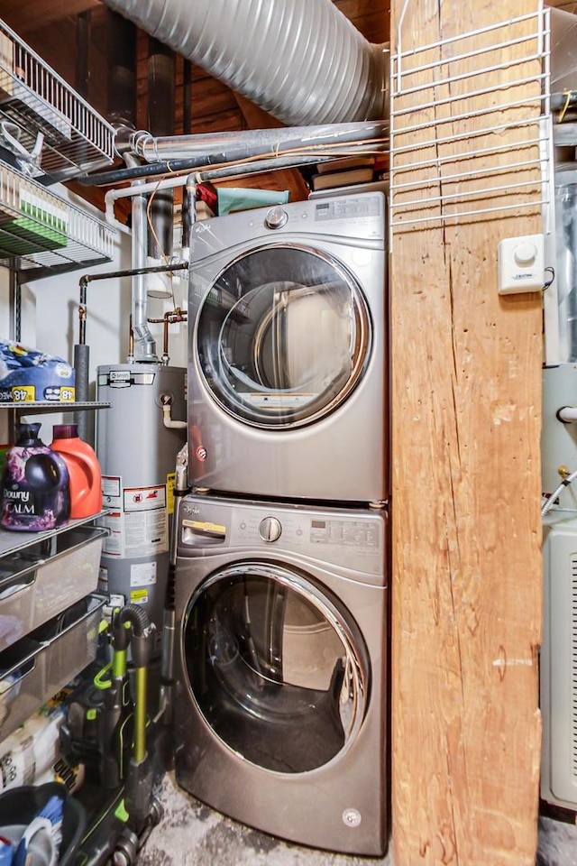 clothes washing area with wood walls, stacked washer and clothes dryer, and gas water heater