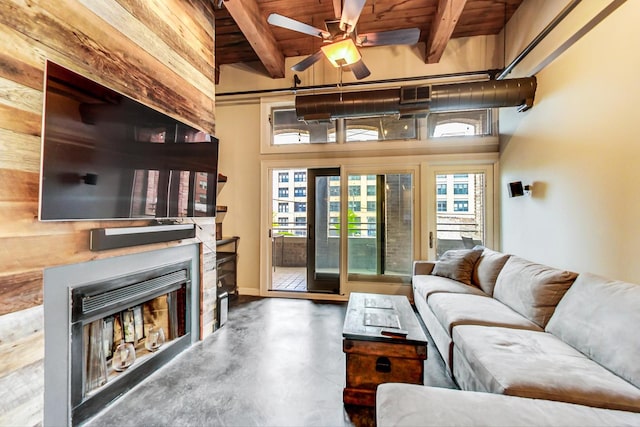 living room with beamed ceiling, concrete flooring, wood ceiling, and wooden walls