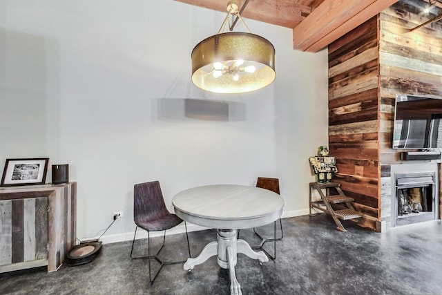 dining space featuring concrete flooring and wooden walls