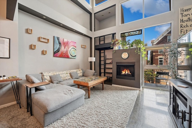 living room with a towering ceiling, a wealth of natural light, and hardwood / wood-style floors