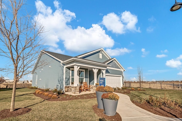 view of front facade with a front lawn, a garage, and a porch