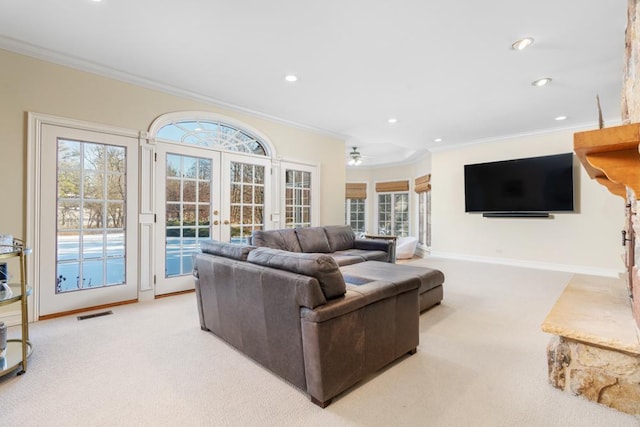 living room featuring light carpet, ornamental molding, and french doors