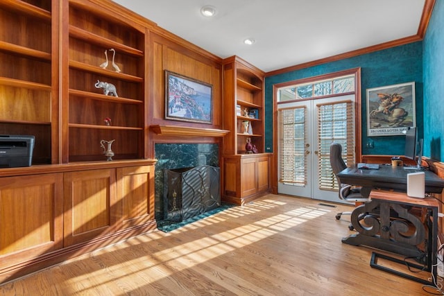 office featuring crown molding, light hardwood / wood-style floors, french doors, and built in shelves