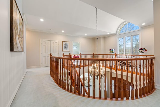 hall with light carpet, crown molding, and an inviting chandelier