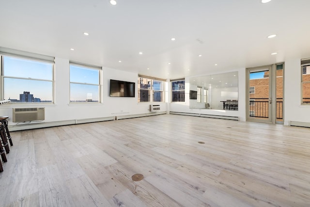 unfurnished living room featuring a wall mounted AC, baseboard heating, and light hardwood / wood-style flooring