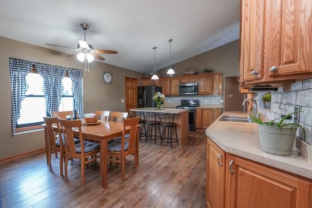 dining space featuring dark wood-type flooring, sink, lofted ceiling, and ceiling fan