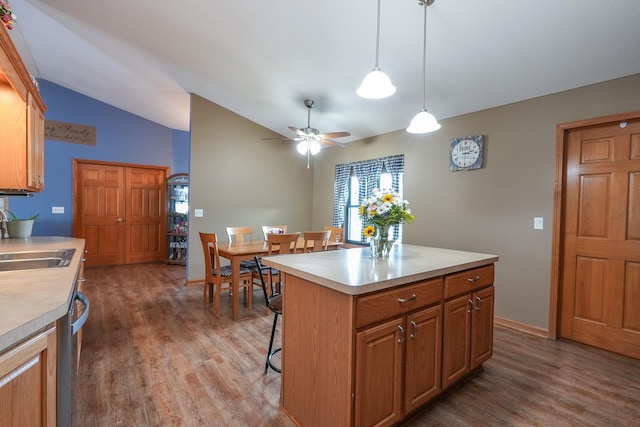 kitchen with lofted ceiling, dark hardwood / wood-style floors, a kitchen island, sink, and hanging light fixtures