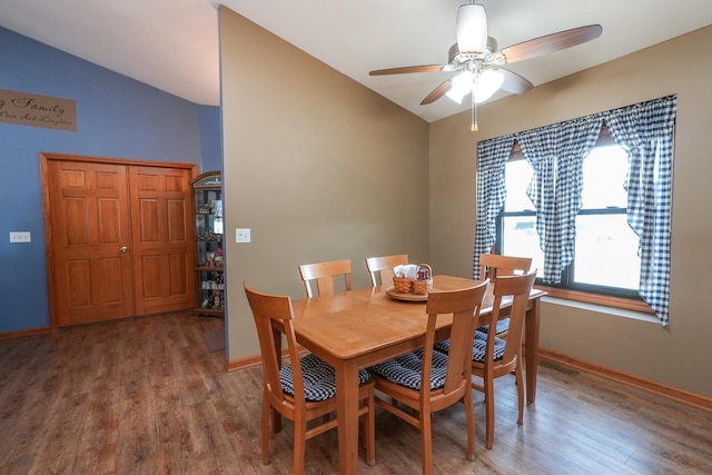 dining area featuring ceiling fan, hardwood / wood-style floors, and vaulted ceiling