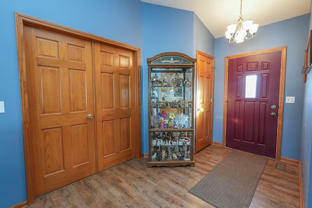 foyer with light hardwood / wood-style floors and a notable chandelier