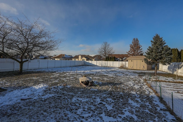 snowy yard with a storage shed