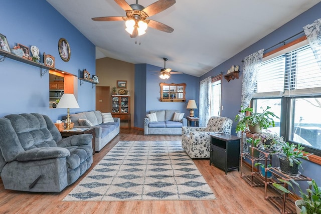 living room with hardwood / wood-style flooring, ceiling fan, and vaulted ceiling