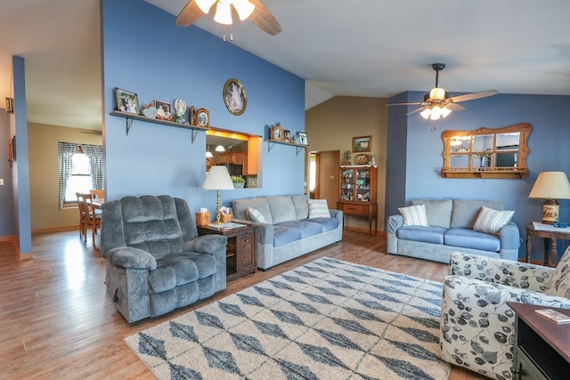 living room featuring ceiling fan, vaulted ceiling, and light hardwood / wood-style floors