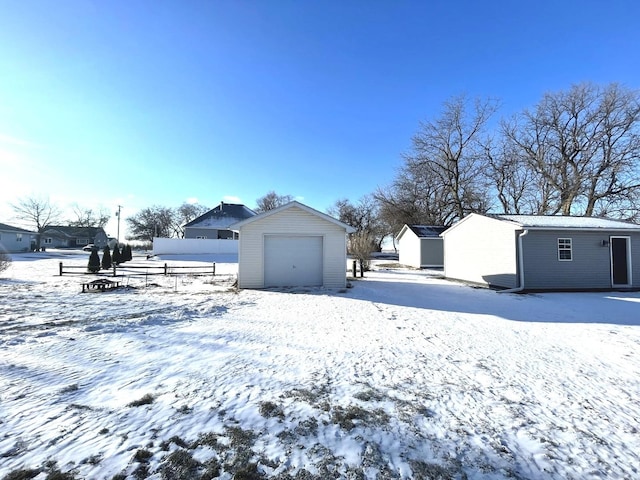 snowy yard with an outbuilding and a garage