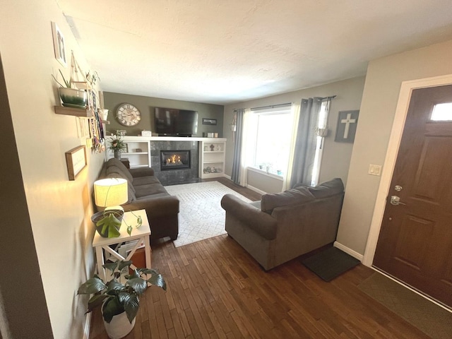 living room featuring a tile fireplace and dark hardwood / wood-style flooring