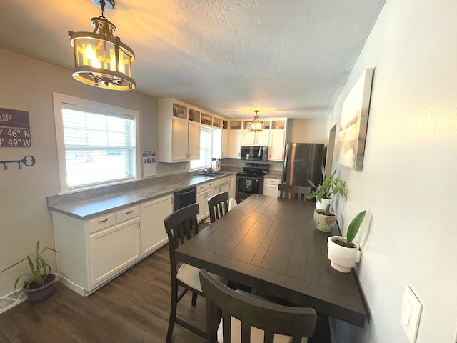 dining space with sink, a textured ceiling, dark hardwood / wood-style floors, and an inviting chandelier