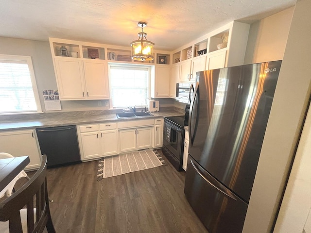 kitchen with range with electric stovetop, hanging light fixtures, sink, black dishwasher, and stainless steel refrigerator